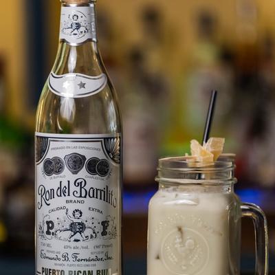 A bottle of Puerto Rican rum beside a Pina colada.