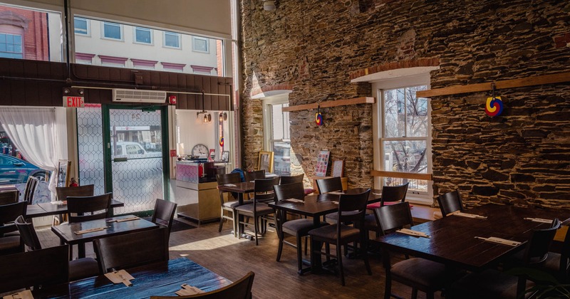 Interior, lined up tables and chairs by the windows