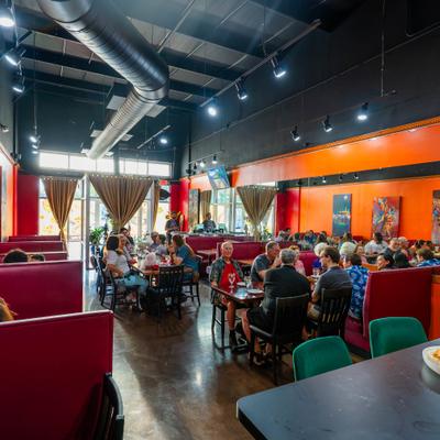 Dining room featuring distinct orange walls and red booth seating.