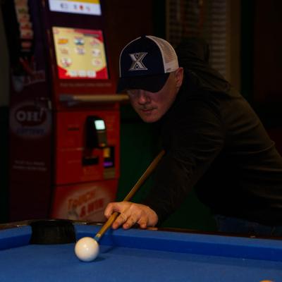 Staff member playing pool.