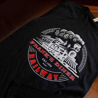 Black T-shirt featuring a steam train graphic with Frank's Diner Railway printed in red and white.