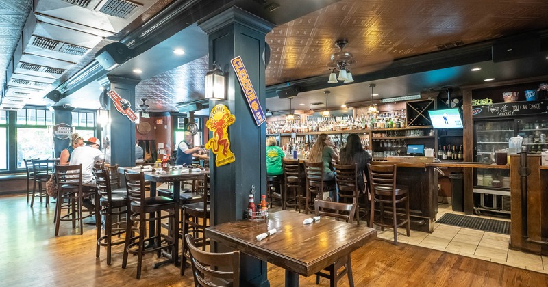 Interior, table and chairs, guests sitting at the bar