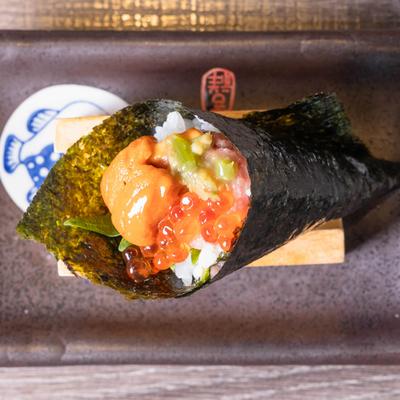Hand roll with sea urchin roe, shiso leaf, salmon roe, and wasabi.