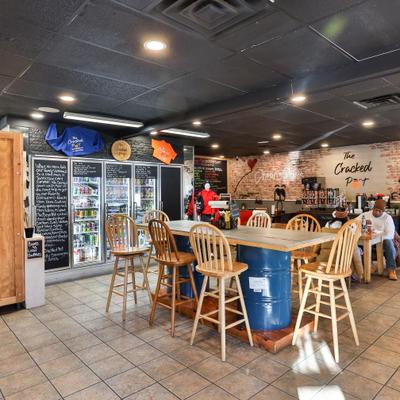 Interior with both regular and a high-top tables and refrigerated display cases.