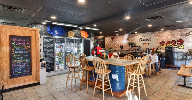 Casual dining space with a long table at the center and glass-front refrigerators