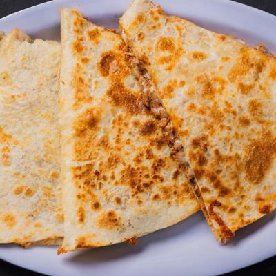 Quesadilla Birria sliced and served on the plate, close-up.