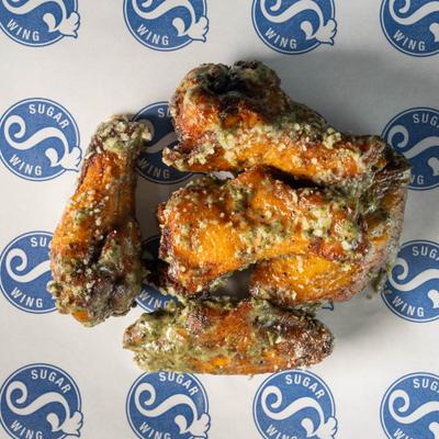 Garlic Parmesan chicken wings on branded parchment paper.