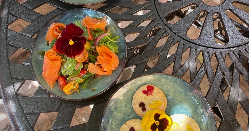 Smoked salmon salad and cookies served on a table outside