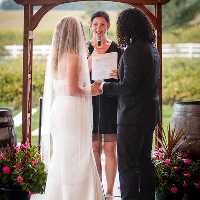 Officiant standing between a couple during a ceremony at Next Chapter Winery.