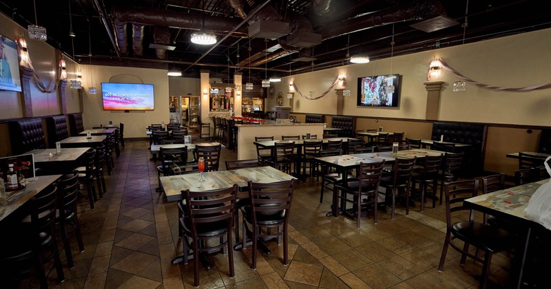 Interior, wide shot of dining area, TV's on the walls