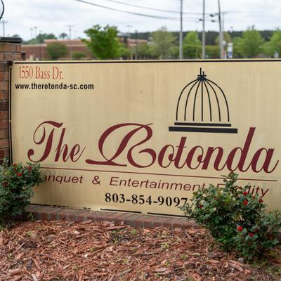 Standalone Rotonda banquette and entertainment facility sign with info and landscaping.