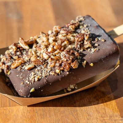 Chocolate popsicle topped with crushed walnuts.