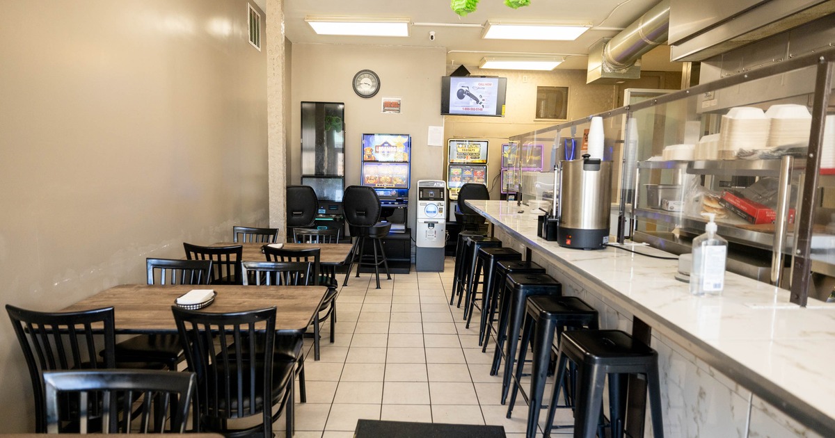 Interior, dining area with tables and chairs, a counter with stools
