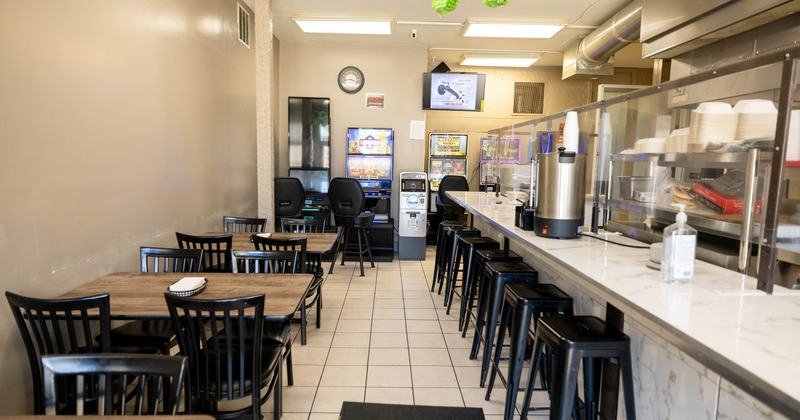 Interior, dining area with tables and chairs, a counter with stools