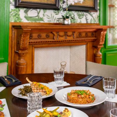 Assorted meals and tableware on a table by an antique fireplace
