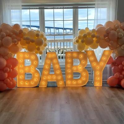 Illuminated BABY letters framed by balloons.