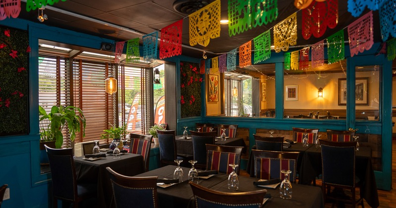 Mexican-style interior dining area decorated with hanging paper ornaments