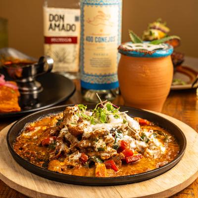 Queso Fundido on a table with drinks.