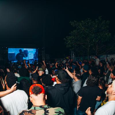Crowd gathered at the open air nighttime concert event.