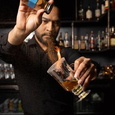 A person preparing a cocktial.