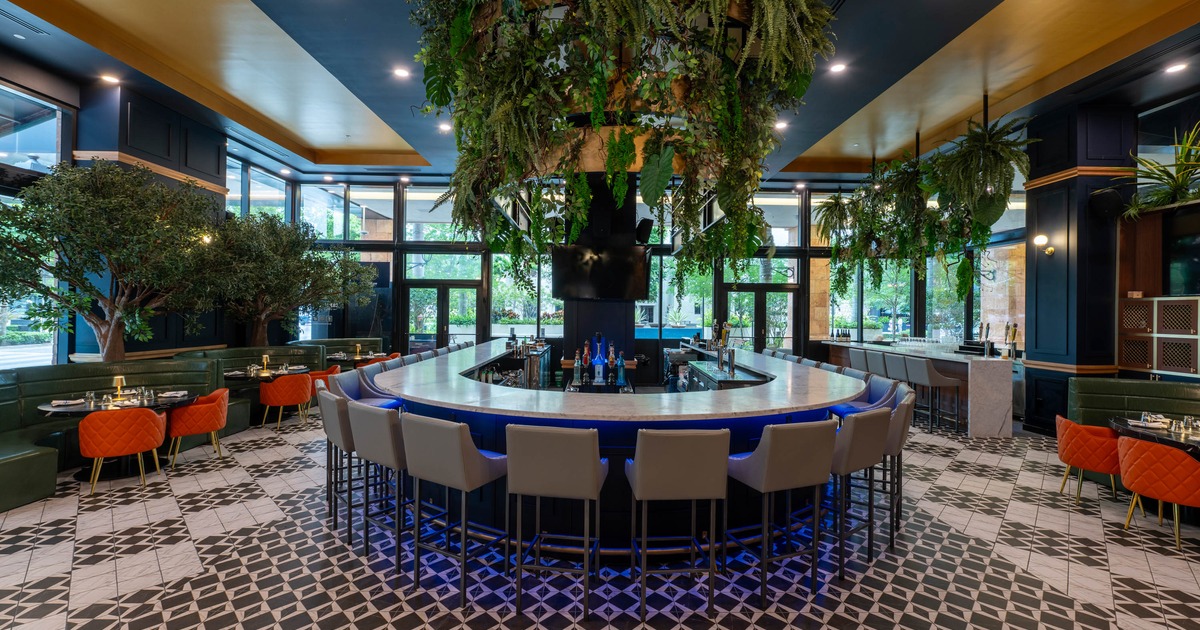 Interior, shot of the bar and seating area, large room centered bar with stools, banquette seating