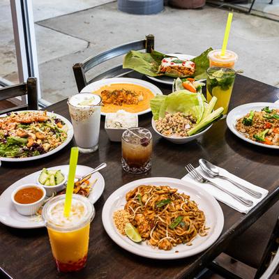 Thai dishes and drinks served on a wooden table.