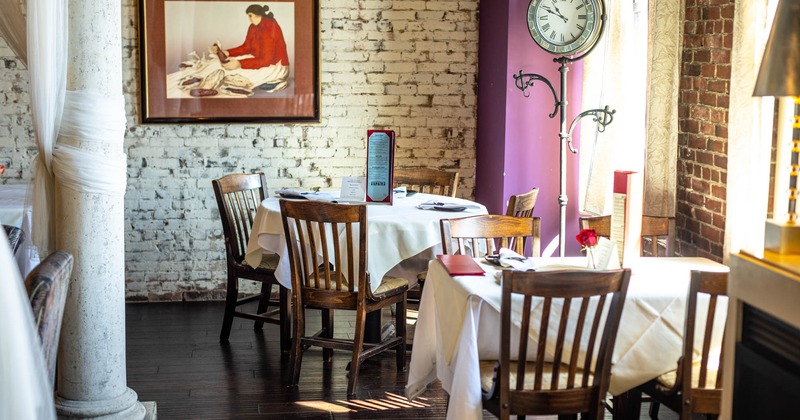 Interior, corner seating area, brick walls, painting, clock in the corner, windows on the right