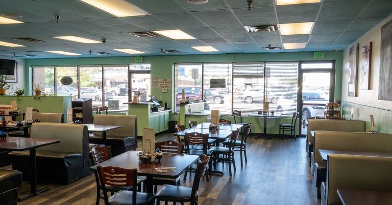 Interior of spacious dining area with dining tables, chairs, and upholstered booths