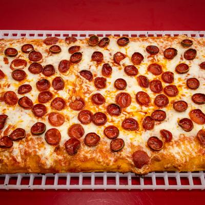 Square Pepperoni pizza on a white plastic serving tray.