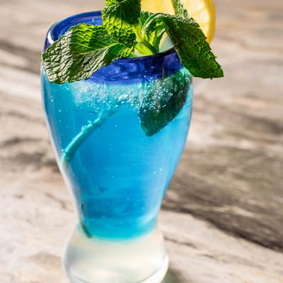 Blue Lemonade garnished with mint sprig and a lemon wheel.