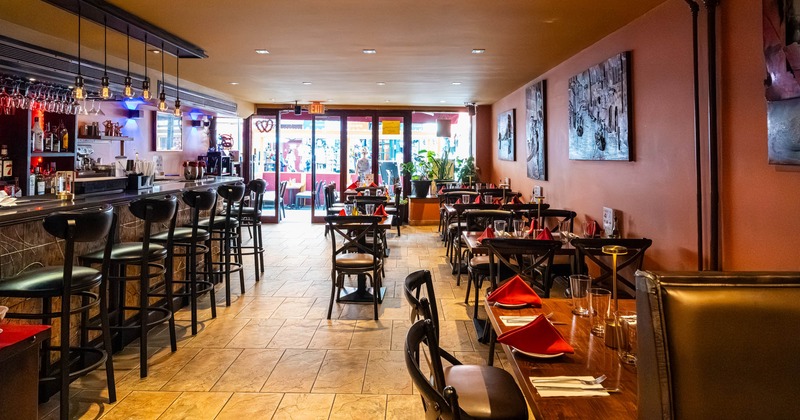 Interior, tables and chairs on the right, bar and bar stools on the left