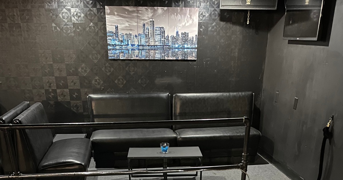 Black seating in front of a dark wall with artwork