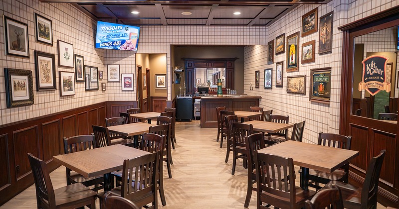 Dining room with wooden tables, chairs, and wall art