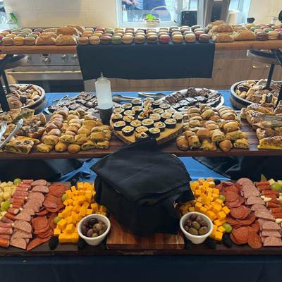 Grazing table with  a variety of finger foods, including meats, cheeses, fruits, and olives.