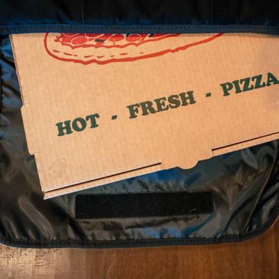 Pizza box inside a delivery bag.