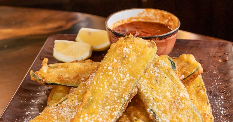 Fried zucchini with marinara and lemon wedges