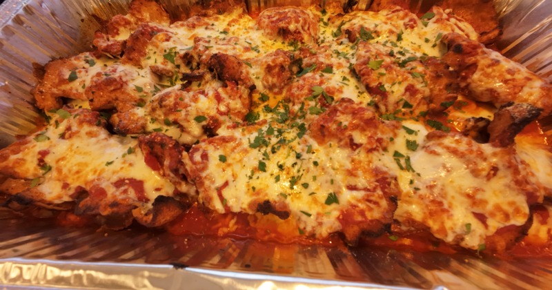 Baked chicken Parmesan in a catering tray