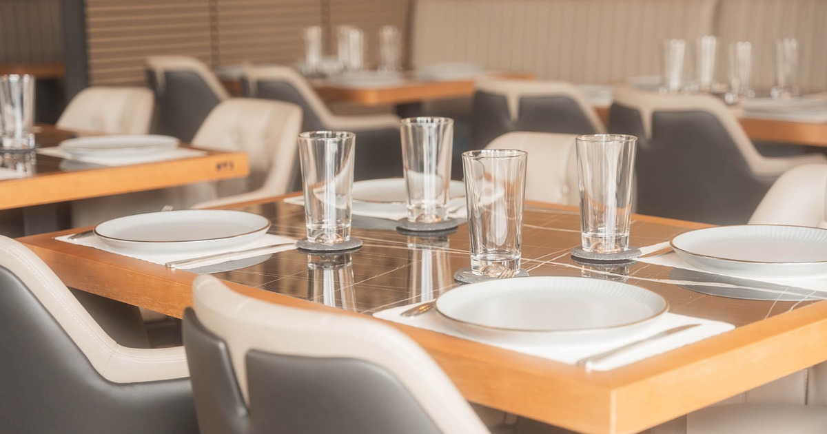 Neatly set restaurant table with plates, glasses, and napkins