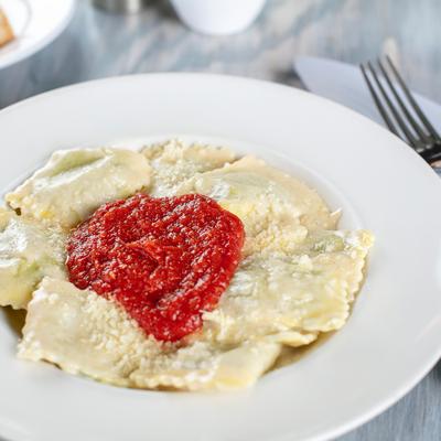 Tortelli di Spinaci  House made Large Ravioli spinach, Ricotta cheese pancetta Bechamel cream sauce & Pomodoro sauce.