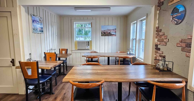 Interior, dining area with wooden tables, chairs and white paneled walls