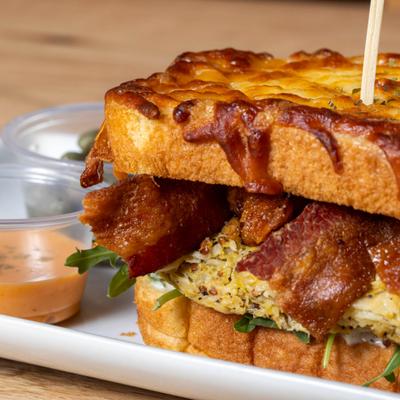 Bacon Egg And Cheese Omelette Sandwich served with a side of dipping sauce.