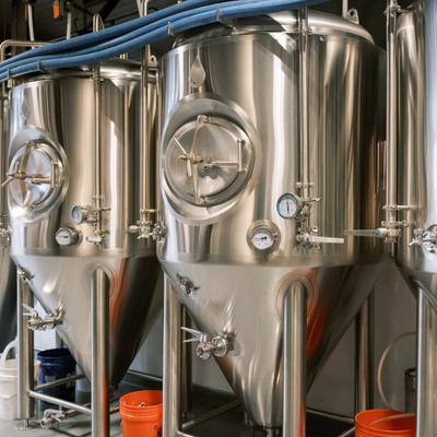 Stainless steel brewing tanks with round doors.