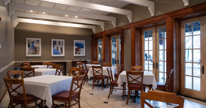 Interior, private dining area, tables with chairs for four people, wooden balcony doors