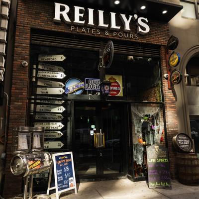 Exterior of Reilly’s Plates and Pours restaurant and bar with neon beer signs.