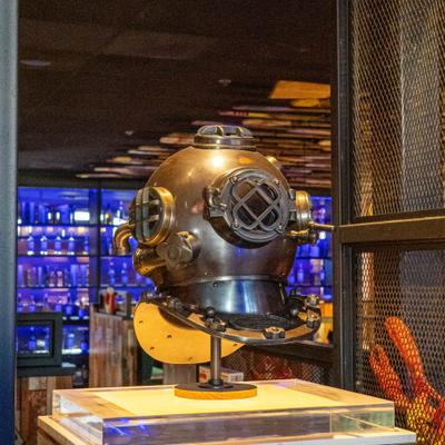 Interior details, a vintage diving helmet displayed on a glass stand.