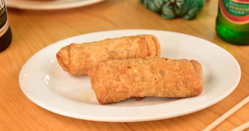 Two egg rolls on a white plate