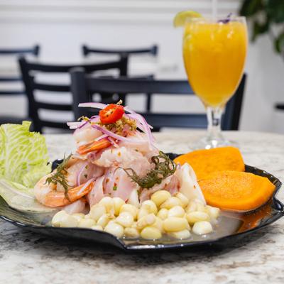 Peruvian-style ceviche served alongside corn, sweet potatoes, and passion fruit juice.