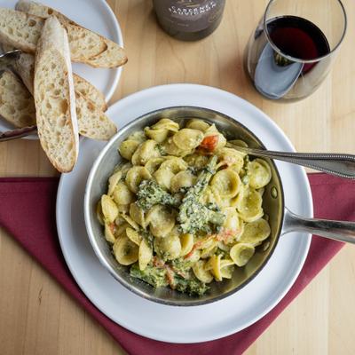 Orecchiette pasta paired with broccoli, garlic, and cheese, served alongside bread.