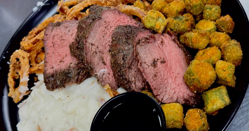 Sliced roast beef served with mashed potatoes, onion rings and fried okra