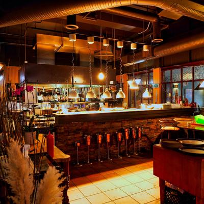 Open restaurant kitchen with hanging lights above the counter..